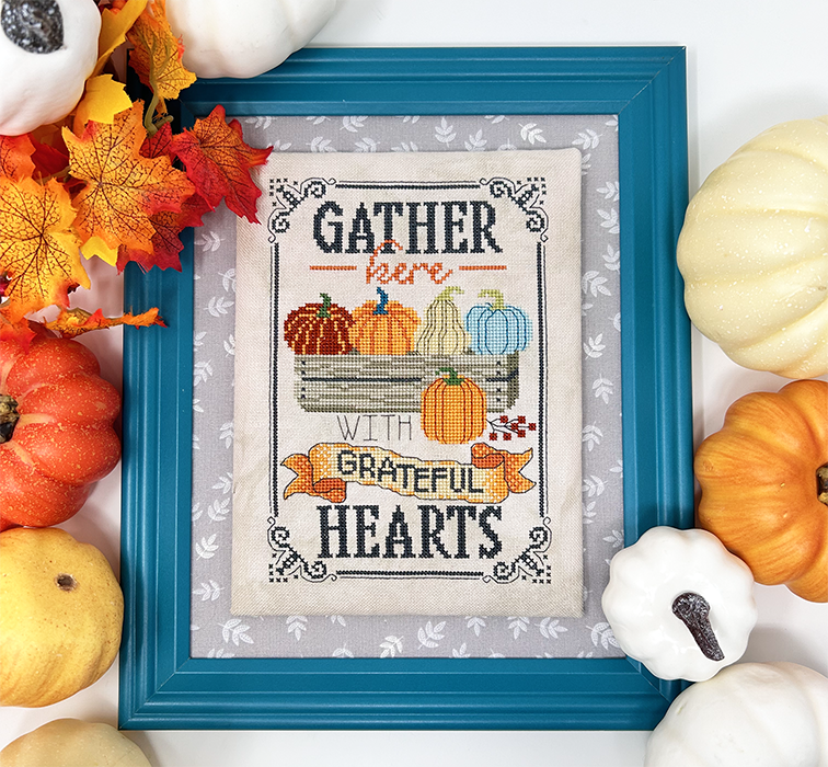 Pumpkins in wooden box with the words “gather here with grateful hearts”