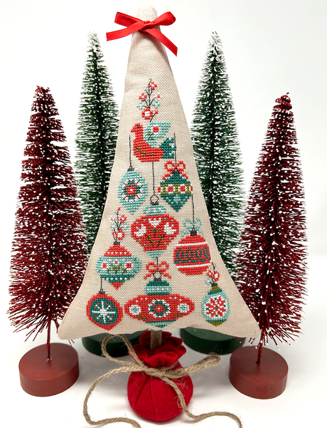 Festive ornaments with bird on top of tree