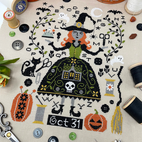 witch in spooky dress with pumpkins and cat