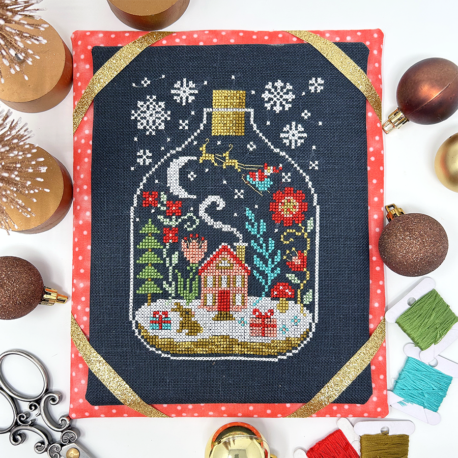Winter house and flowers in glass bottle
