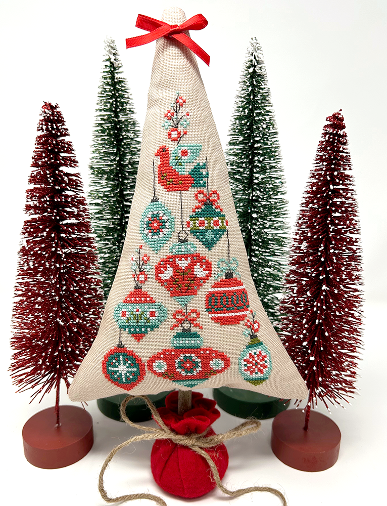 Festive ornaments with bird on top of tree
