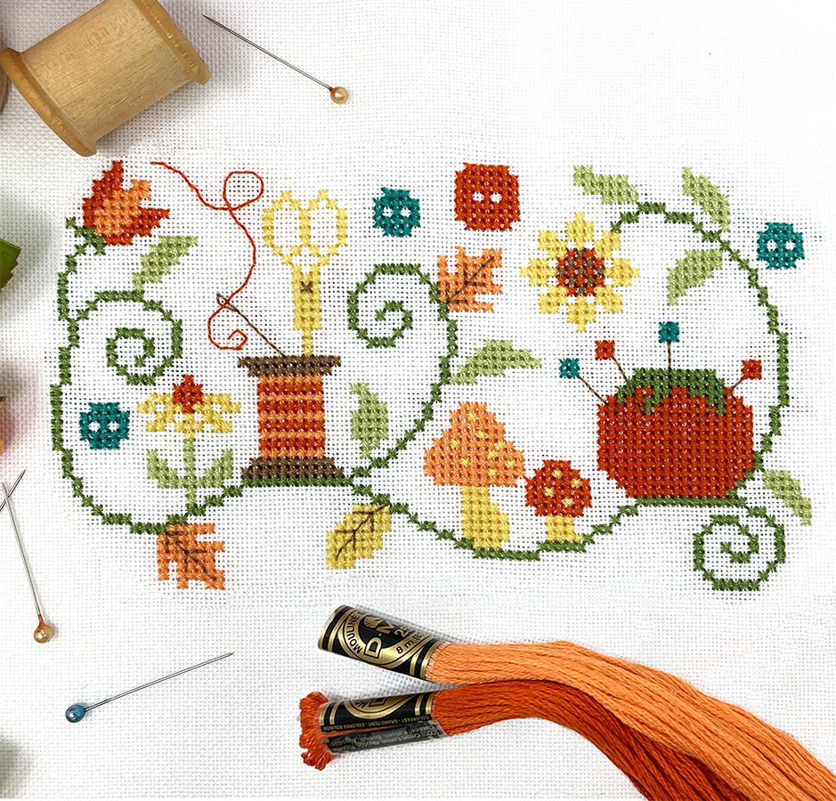 Vines with leaves and flowers, pin cushion, thread and scissors 