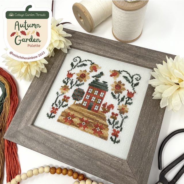 Autumn house on hill with bird on top and flowers