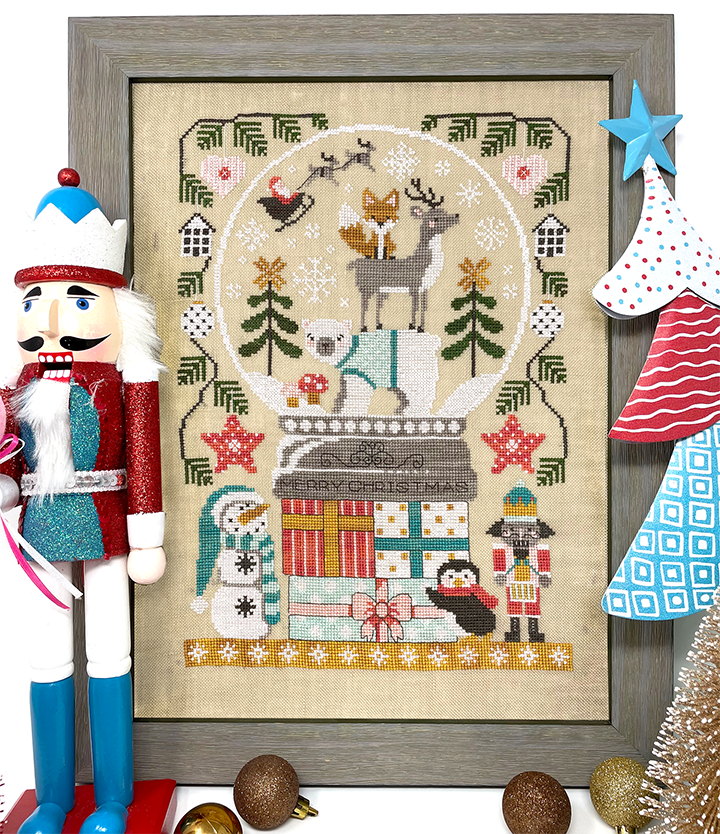 Christmas snow globe on presents with animals and festive greenery