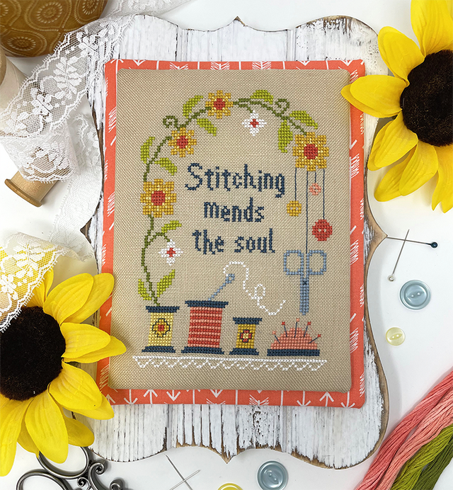 Thread scissors and flowers with the words stitching mends the soul 